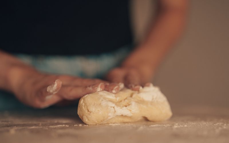 Hands kneading dough in a home kitchen